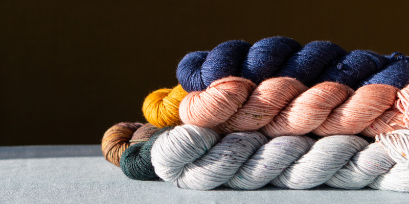 A pile of Life in the Long Grass DK Twist yarns for our Spring Seasons Knitting Club 2026