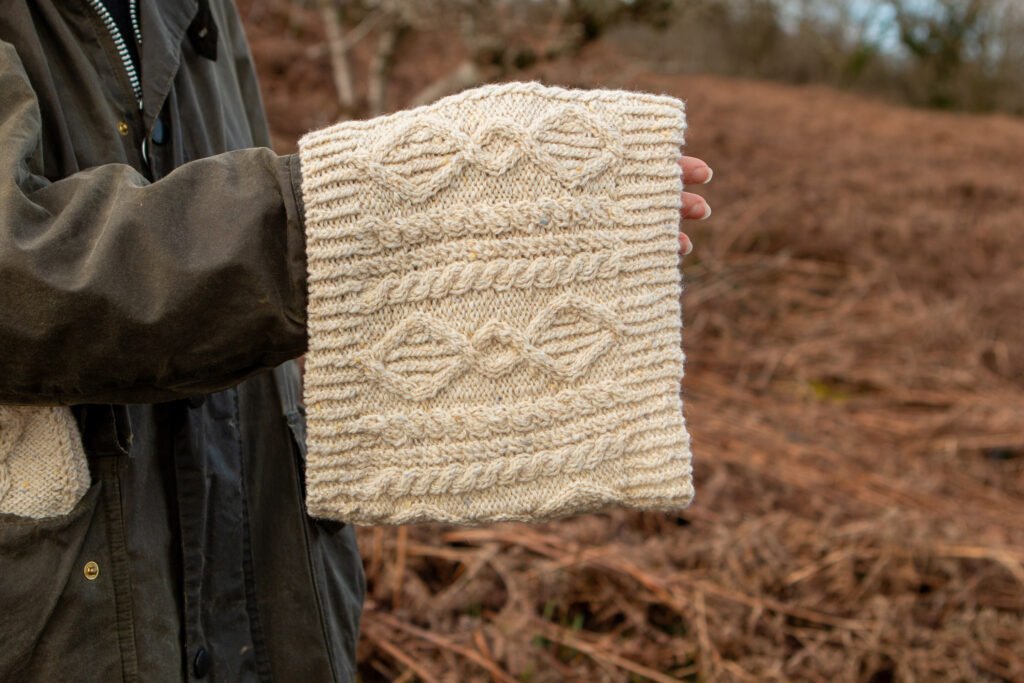 Close up of the knitted cables of the Fionbarra cowl in Solas yarn in cream. 