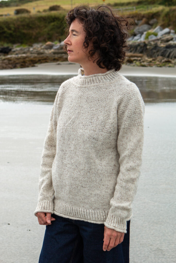 Carol wearing a cream Nadur Blasta unisex sweater from the Lucas knitting pattern. 
